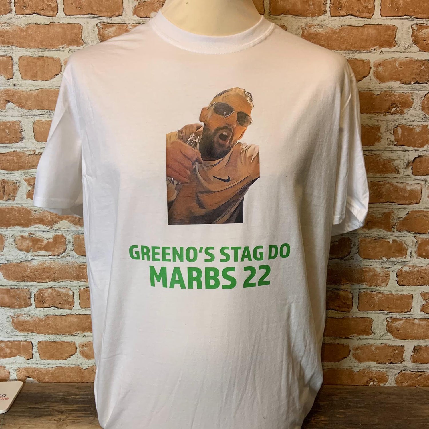 White t-shirt with a graphic and text on a brick wall background for a stag dip. Made by The Wrong End of Town in Dover, Kent.